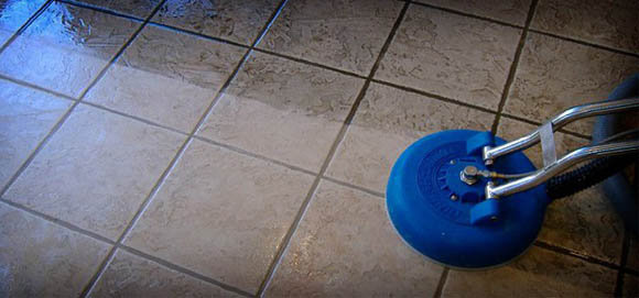 This image shows a man using a polisher machine to clean the tiles.