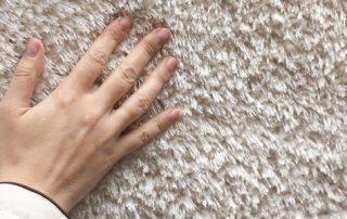 This image shows a hand pressed against the carpet.