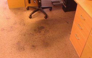 This image shows an office carpet that has a lot of stains.